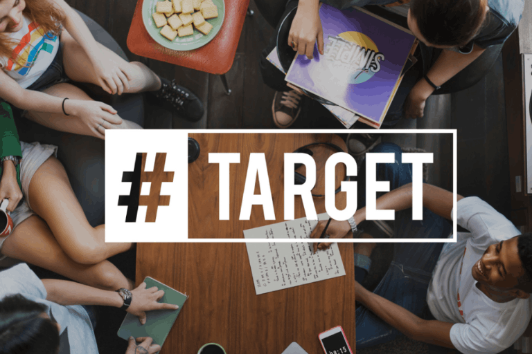 Team discussion around a table with #Target text overlay representing high-intent audience targeting in digital marketing.