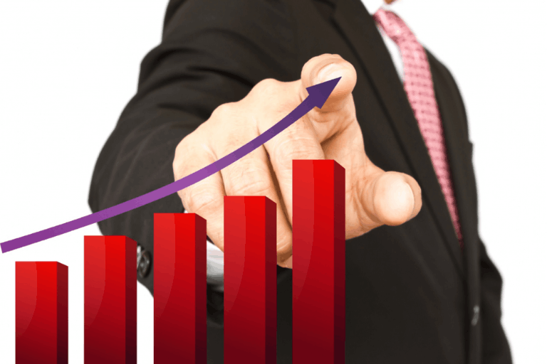 Business professional pointing at a rising bar chart representing scaling growth without increasing overhead in marketing.
