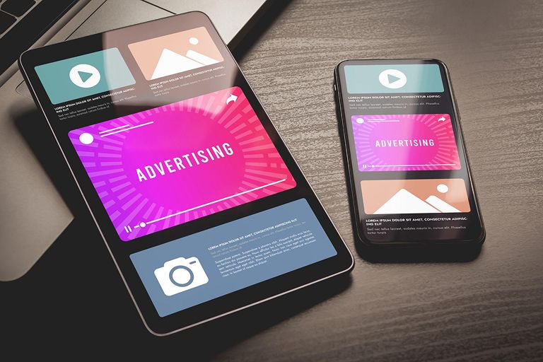 Tablet and smartphone displaying consistent advertising creatives across platforms for omnichannel marketing campaigns.