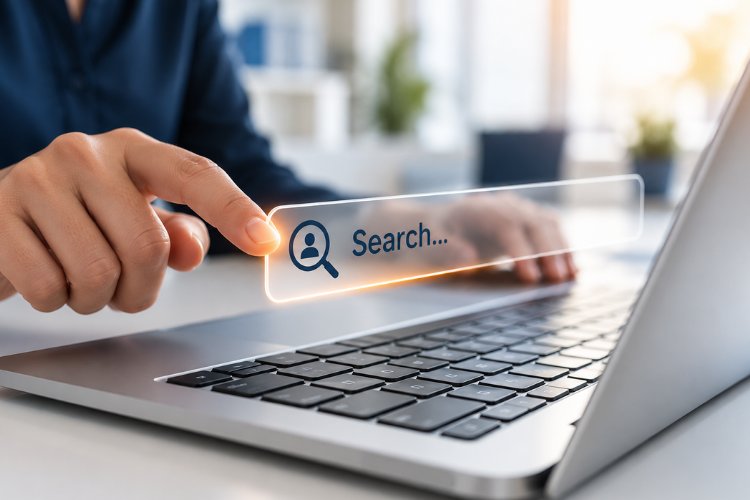 A finger tapping a glowing search bar with a person icon floating above a laptop keyboard, illustrating search engine marketing